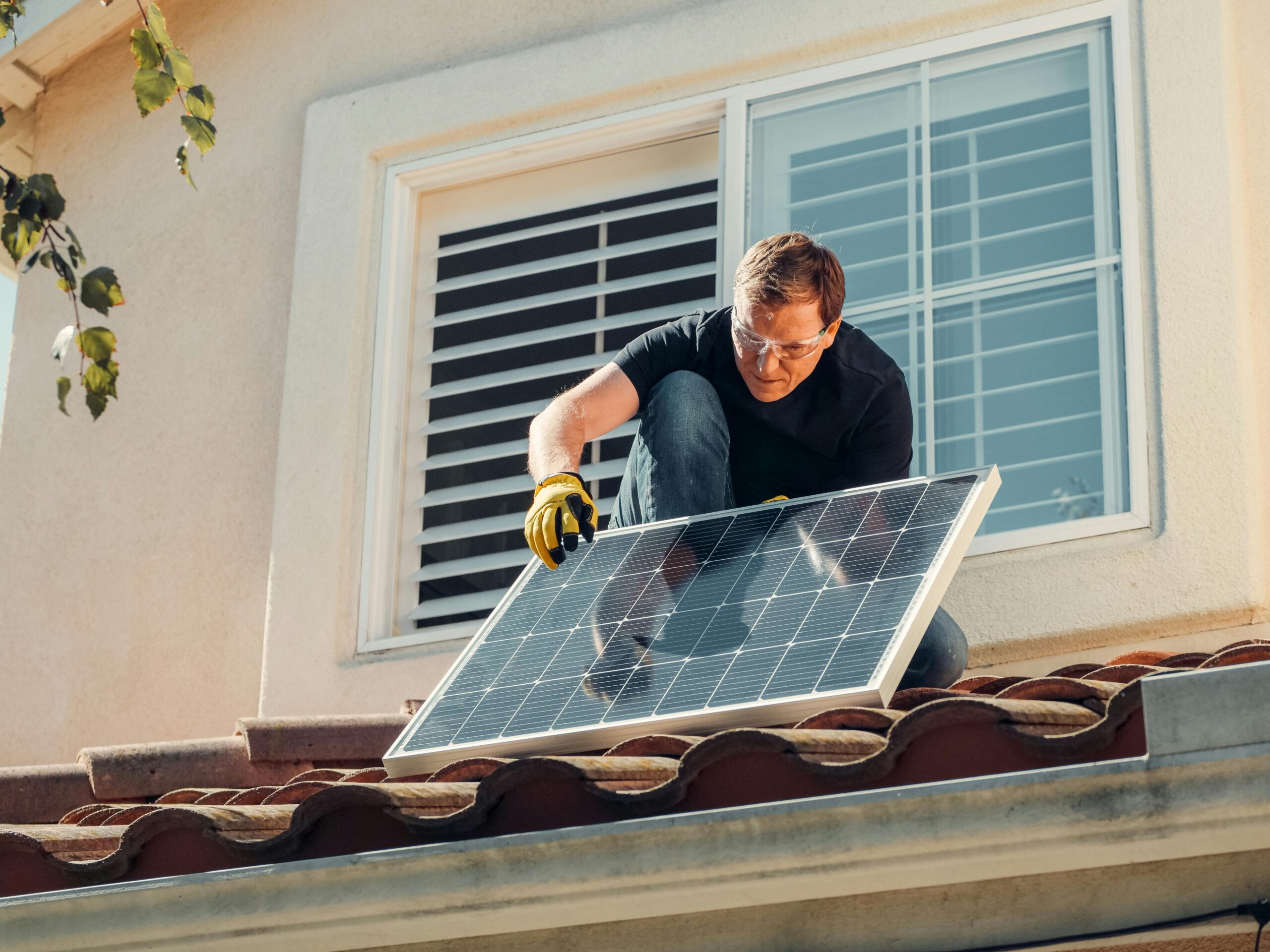 Solar technician installing rooftop solar panels on a residential home in California